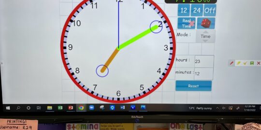 Flat panel display in a primary school classroom displaying a clock and timer to keep students on track.