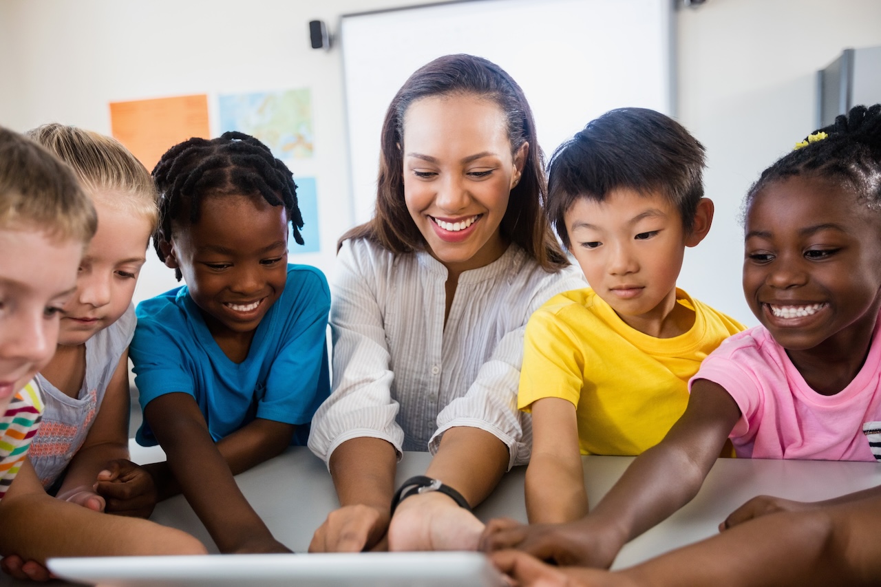 Portrait of teacher with pupil using tablet pc