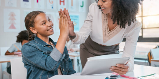 Teacher interacting with student classroom.