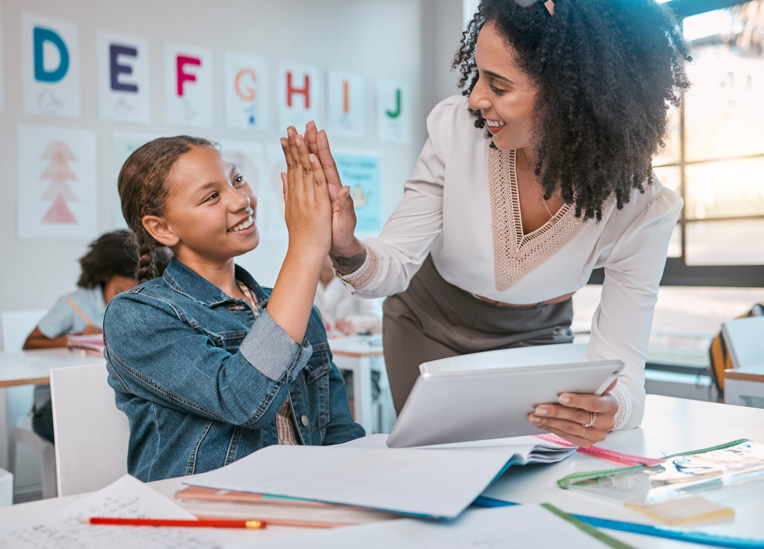 Teacher interacting with student classroom.