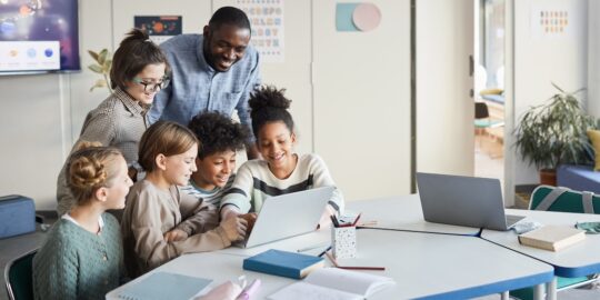 Group of Kids Looking at Computer Screen in School